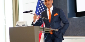 USA Hamdani in suit speaking at podium