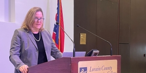 Acting U.S. Attorney Carol Skutnik speaking at a podium.