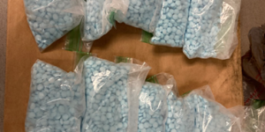 Image of several bags containing blue counterfeit fentanyl-laced pills seized from Lonnie Laronn Marrow in Kalamazoo