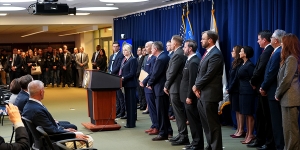 Attorney General Pamela Bondi delivers remarks from a podium at the U.S. Attorney’s Office for the Eastern District of New York. She is joined by federal government officials.