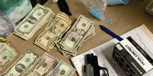 Seized firearm, fentanyl pills, and cash.  