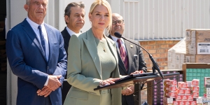 Attorney General Pamela Bondi delivers remarks from a podium in front of a vape products distribution center in Chicago, Illinois. She is joined by HHS Secretary Kennedy and federal government officials.