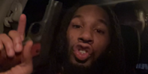 Image of man holding pistol in a car