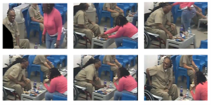Still images from surveillance footage showing one defendant passing K2-laced papers to the other defendant in prison