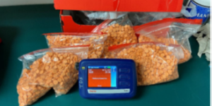 multiple plastic baggies containing orange pills