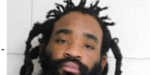 Photo of man with beard in front of concrete background