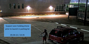 A man allegedy launches a drone next to a red Chevy Tahoe