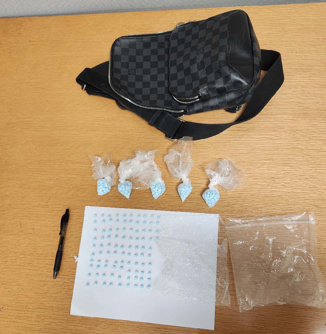 black bag, pills and baggies on a table