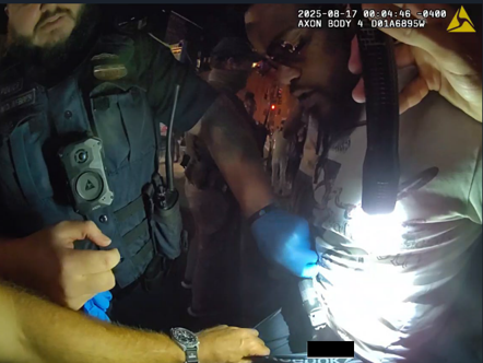 Still from police body-worn camera showing the recovery of the firearm from Myrick’s pants.