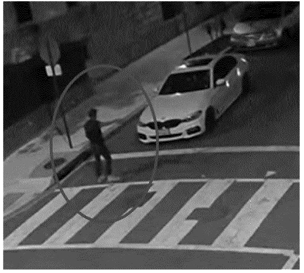 Man in street in front of car pointing at someone