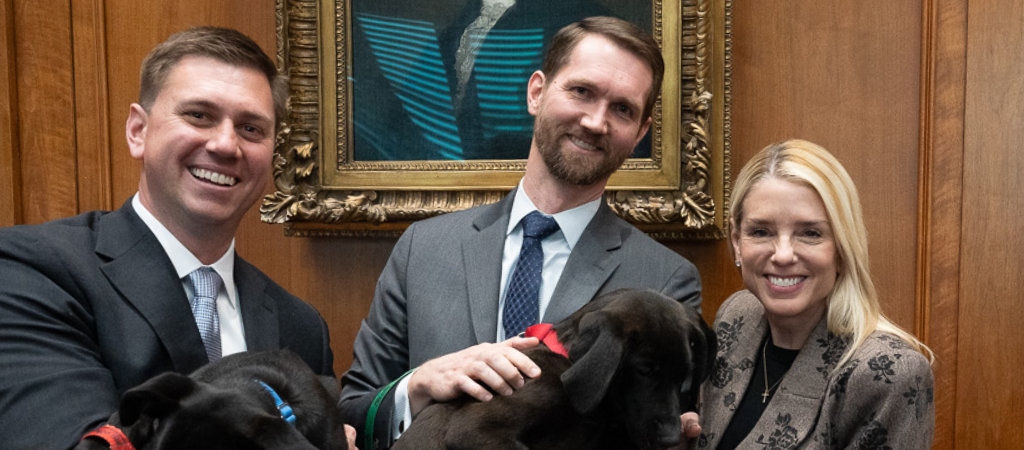 Leadership and other Animal Welfare Roundtable participants holding puppies at event
