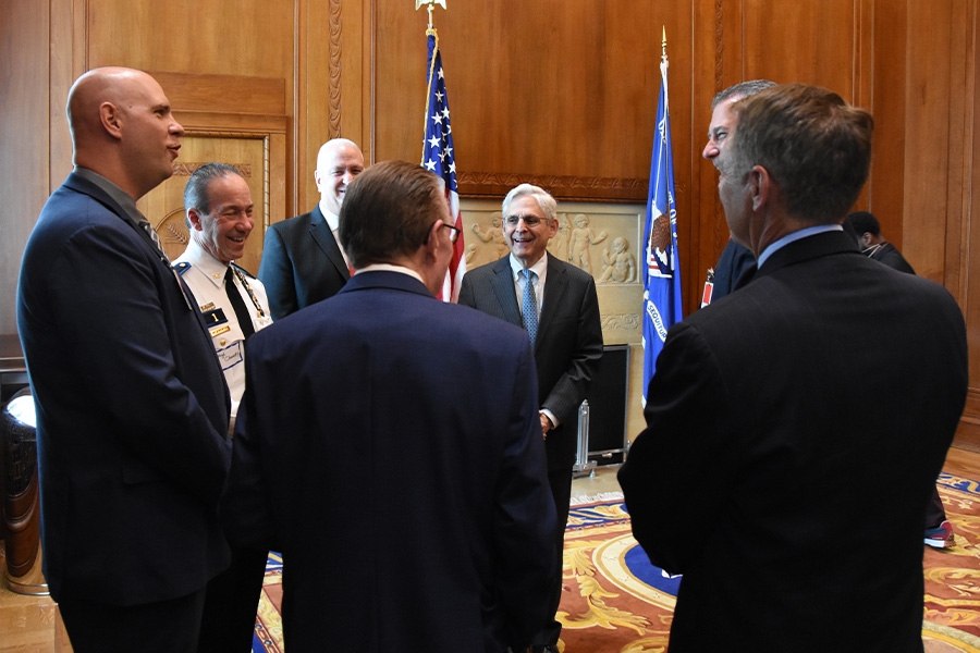 AG Garland converses with law enforcement officials.