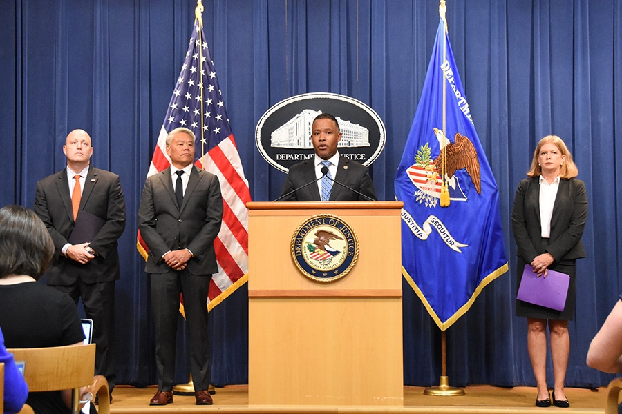 Assistant Attorney General Kenneth A. Polite, Jr. speaks at a podium bearing the Department of Justice Seal.