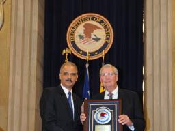 Attorney General Eric Holder honors former Assistant Attorney General James F. Rill with the 2012 Sherman Award.