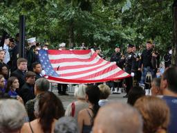 Soldiers present the American flag during the 15th anniversary ceremony at the National September 11 Memorial Plaza