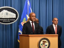 U.S. Attorney Damian Williams speaks at the podium. Behind him are FBI Associate Deputy Director Brian Turner and Assistant Director Luis Quesada of the FBI’s Criminal Investigative Division.