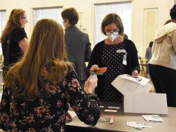 A woman participates in the Reentry Simulation, going through the process of obtaining public transportation tickets.