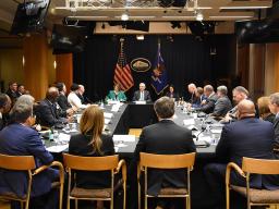 Officials of law enforcement sit in a round table formation. To the left in green is Deputy Attorney General Lisa O. Monaco, in the middle we see Attorney General Merrick B. Garland, and to the right of the Attorney General is Associate Attorney General Vanita Gupta.