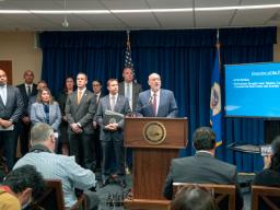 Attorney Andrew M. Luger from the U.S. Attorney’s Office for the district of Minnesota speaks at a podium bearing the Department of Justice seal.