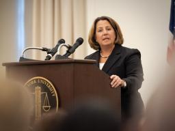 Deputy Attorney General Lisa O. Monaco speaks to an audience of officials and attorneys at a podium bearing the New York University seal.