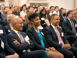 An audience composed of attorneys, officials, and other experts smile at the Deputy Attorney General’s response to a question