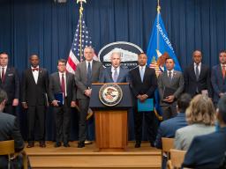 Assistant Attorney General Matthew G. Olsen of the Justice Department's National Security Division delivers remarks from a podium bearing the Department of Justice seal
