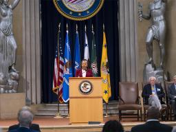Assistant Attorney General for Civil Rights Kristen Clarke delivers remarks at a podium in the Robert F Kennedy Main Justice Building’s Great Hall.