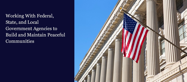 American flag flying between the columns of the Department of Commerce building in Washington, D.C.