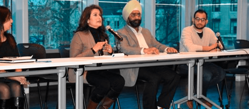 Two women and two men sit at a table in front of a room during a Bias Incidents and Hate Crimes Forum.
