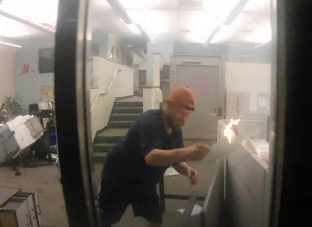 Schinzing spreading the fire in the Corrections Records Office by moving flaming papers into separate cubicles on May 29, 2020 Schinzing spreading the fire in the Corrections Records Office by moving flaming papers into separate cubicles on May 29, 2020