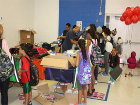 Kids receiving free backpacks and clothing at Yo Boulevard! Block Party.